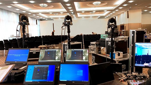 Tagungssaal mit Kameras, Laptops und Monitoren vor Beginn eines Kongresses